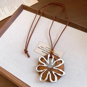 Vista detallada de un colgante de madera rústica con un elegante diseño de flor de metal