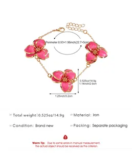 Detalle de pulsera de flores de esmalte rosa con cadena de hierro y cierre de langosta