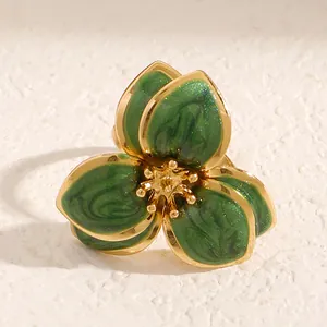 Primer plano detallado de un anillo de flor de esmalte verde oscuro vintage con bordes dorados