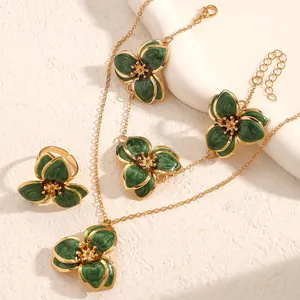 Primer plano de conjunto de joyas vintage de flores de esmalte verde oscuro y dorado