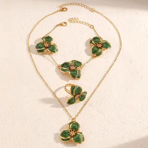 Detalle de un juego de joyas de flores de esmalte verde con collar y anillo