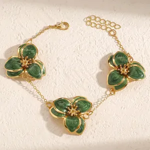 Vista macro detallada de la pulsera vintage de flores de esmalte verde y cadena dorada