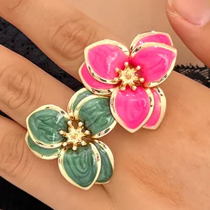 Macro detalle de anillos de flores esmaltados vintage con acabado jaspeado rosa y verde