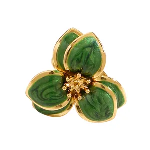 Vista macro de joyas con flores de esmalte verde vintage y bordes dorados