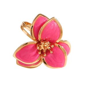 Vista detallada de un elegante anillo abierto con una flor de esmalte rosa en flor