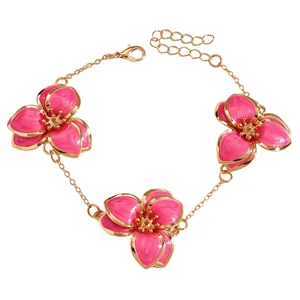 Vista detallada de una elegante pulsera de flores de esmalte rosa con acabado bañado en oro