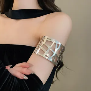 Close-up van een zilveren geometrische uitgesneden armring om de bovenarm