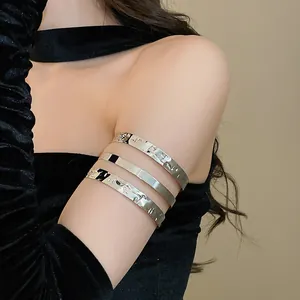 Gedetailleerde weergave van drie zilveren metalen armmanchetten met geplooide textuur