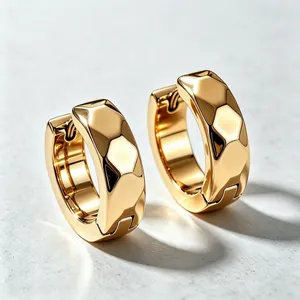 Close-up of gold titanium steel hoop earrings with geometric diamond facets