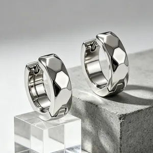 Detailed view of minimalist titanium steel hoop earrings with a geometric faceted finish.