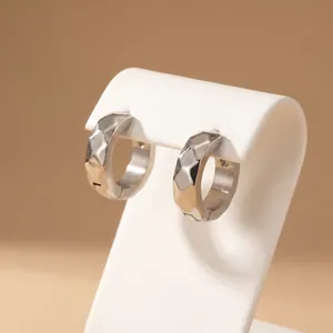 Close-up of 13mm faceted C-shaped titanium steel ear buckles on a white display stand.