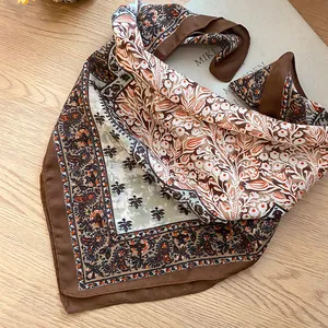Détail du motif paisley rétro sur un foulard carré marron en coton et lin pour femme.