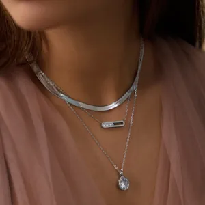 Detailansicht mehrlagiger silberfarbener Halsketten mit Schlangenkette und Zirkonia-Anhängern
