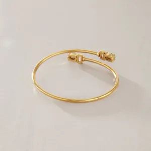 Detailansicht eines goldfarbenen Edelstahlarmreifs mit grünen Zirkonia-Akzenten