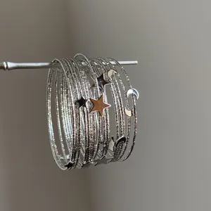 Vue détaillée du bracelet multicouche argenté Y2K avec breloques étoile et lune