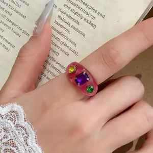 Macro detail van een roze hars ring met levendige kleurrijke ingelegde edelstenen
