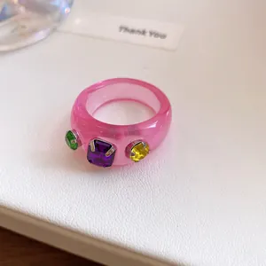 Macrodetail van dopamine roze harsring met kleurrijke vierkant geslepen strass-steentjes