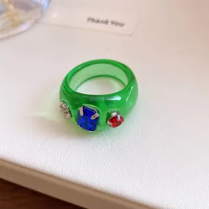 Detailweergave van een groene dopamine-stijl ring van hars met kleurrijke strass-steentjes