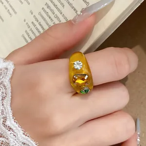 Macro-detail van een amberkleurige harsring in dopaminestijl met gekleurde strass