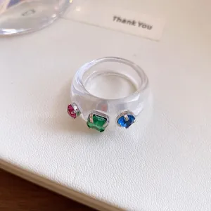 Detailopname van een heldere harsring met levendige veelkleurige vierkante kristallen.
