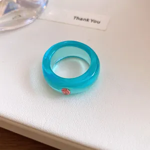 Gedetailleerde opname van een cyaan harsring met een fonkelende roze strass-steen