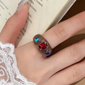 Detailopname van een trendy grijze harsring met levendige rode en blauwe strass