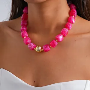 Close-up showing the marbled texture of chunky pink acrylic beads with gold accent