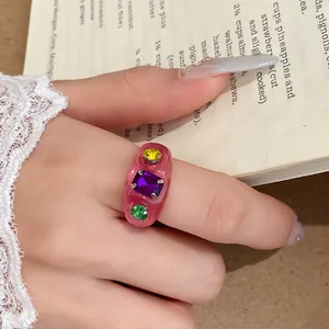 Detailopname van een roze harsring met kleurrijke ingelegde strass-steentjes.