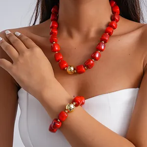 Detailed view of bold red marbled acrylic chunky necklace and bracelet set on model