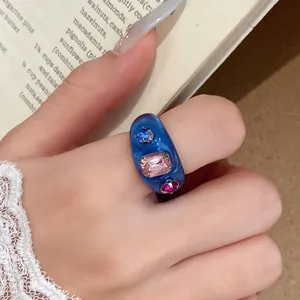 Gedetailleerd macrozicht op een blauwe harsring met fonkelende gekleurde strass.