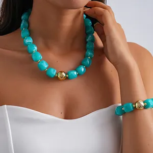 Detailed view of turquoise marbled acrylic necklace and matching bracelet on model