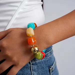 Close-up of a colorful marbled acrylic geometric bead bracelet worn on the wrist