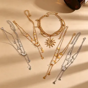 Close-up van bohemian enkellaarsjes met zon, maan, ster en vlinder bedeltjes in goud en zilver
