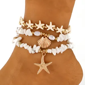 Detail van een bohemien gelaagde enkelband met witte zeester en schelphangers