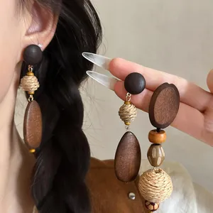 Close-up detail of bohemian style raffia woven and wooden bead drop earrings for women
