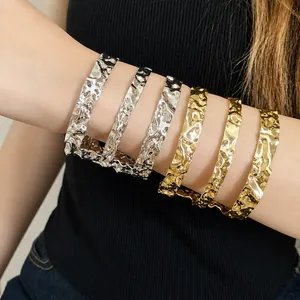 Elegantes brazaletes de metal martillado en oro y plata usados por una modelo
