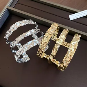 Vista detallada del brazalete de metal de tres capas con un acabado texturizado único