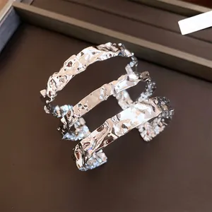 Vista detallada de la textura de un brazalete de metal martillado de tres capas plata