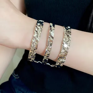 Primer plano de un brazalete de brazo de metal dorado de tres capas con textura rugosa