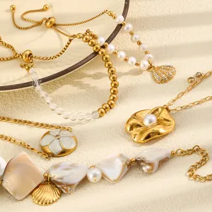 Close-up of gold marine-style jewelry featuring pearls, shells, and flower pendants.