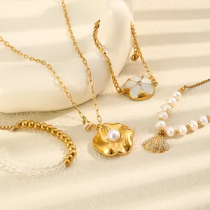 Close-up of 18K gold titanium steel necklaces and bracelets with pearl shell pendants
