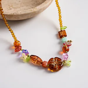 Gros plan d'un collier rétro en perles de verre et acrylique avec motifs floraux et tons ambrés