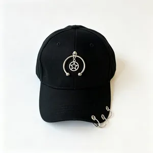 Dettaglio di un cappello da baseball nero con ciondolo a stella e anelli metallici sulla visiera