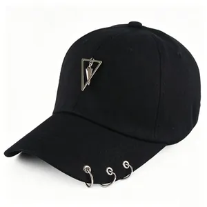 Dettaglio di cappellino da baseball nero con anelli metallici sulla visiera e ciondolo a triangolo