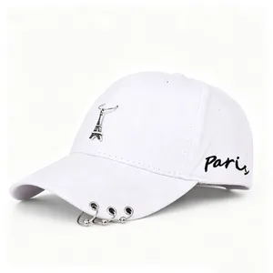 Dettaglio del cappellino da baseball bianco con ricamo Paris e ciondolo torre Eiffel
