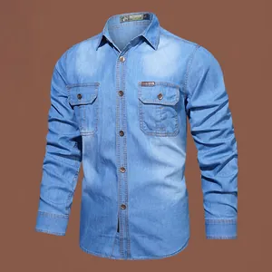 Detail of light blue long-sleeved denim shirt with two chest pockets and stitching