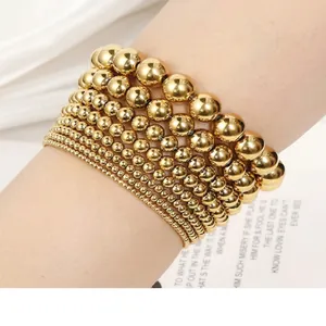 Close-up of seven-layered gold stainless steel beaded stretch bracelets on a wrist.