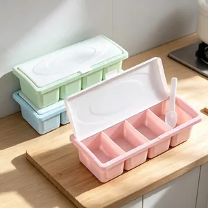 Pastel pink 4-compartment plastic spice container with lid and spoon on wooden board
