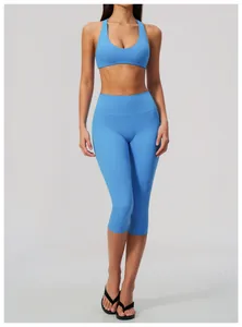 Front view of light blue high-waist capri yoga pants and sports bra set on model