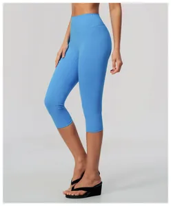 Detail view of high-waisted blue yoga capris on a model for fitness and gym wear.